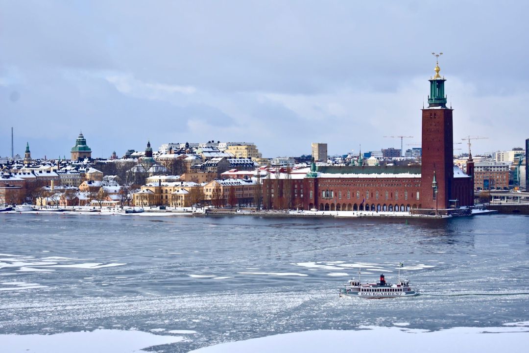 Kapal feri berlayar melewati balai Kota Stockholm.
